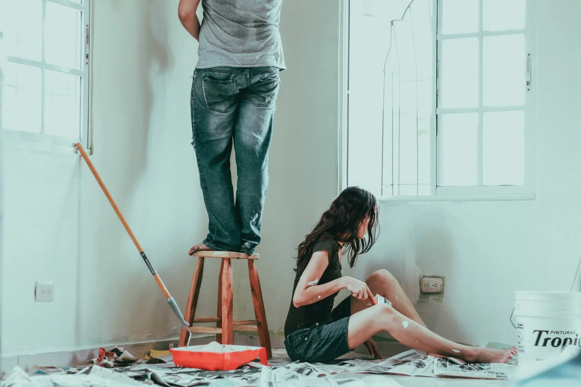 Couple renovating their home, painting walls together